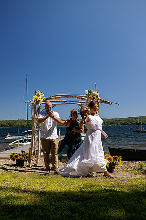 Jenny and Bracy Hood arriving by boat for their Swan Lake Maine wedding ceremony
