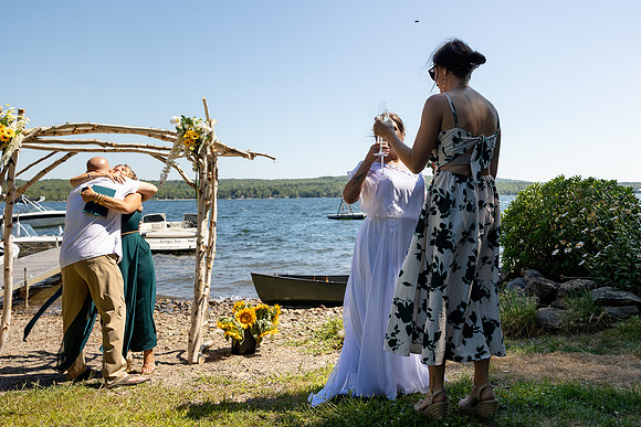 Jenny and Bracy Hood arriving by boat for their Swan Lake Maine wedding ceremony