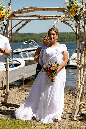 Jenny and Bracy Hood arriving by boat for their Swan Lake Maine wedding ceremony