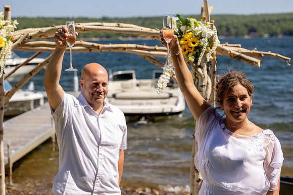 Jenny and Bracy Hood arriving by boat for their Swan Lake Maine wedding ceremony
