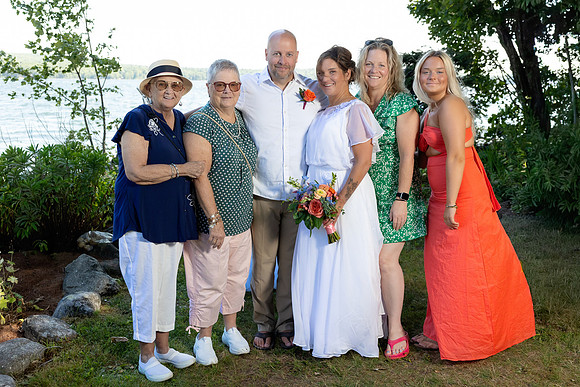 Jenny and Bracy Hood arriving by boat for their Swan Lake Maine wedding ceremony