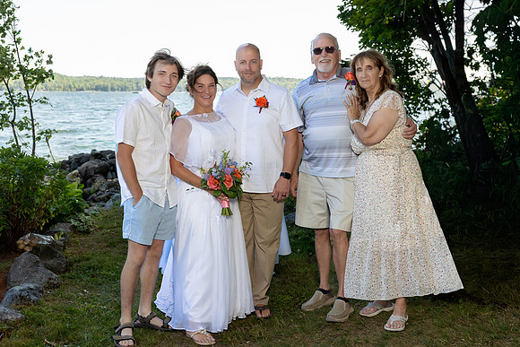 Newlyweds celebrating at lakeside wedding in Swanville Maine