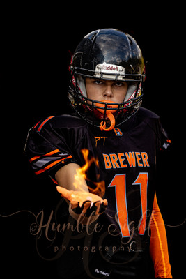 Maine sportraits photographer Brewer Youth Football athlete with fire in their hand taken by Humble Sight Photography