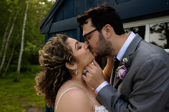 Bride and groom share a kiss during wedding portraits at Grace on the Lake