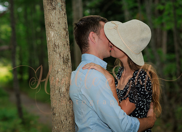 Couple walking wooded trail during Maine engagement session