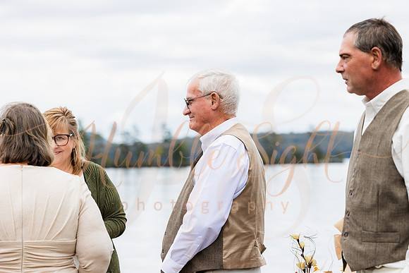 Bride and groom on dock in Maine lake wedding