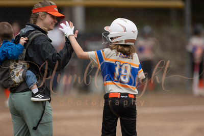 Coach and player high-five at first base during little league softball game Maine sports photographer Humble Sight Photography
