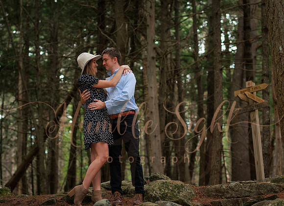 Couple walking wooded trail during Maine engagement session
